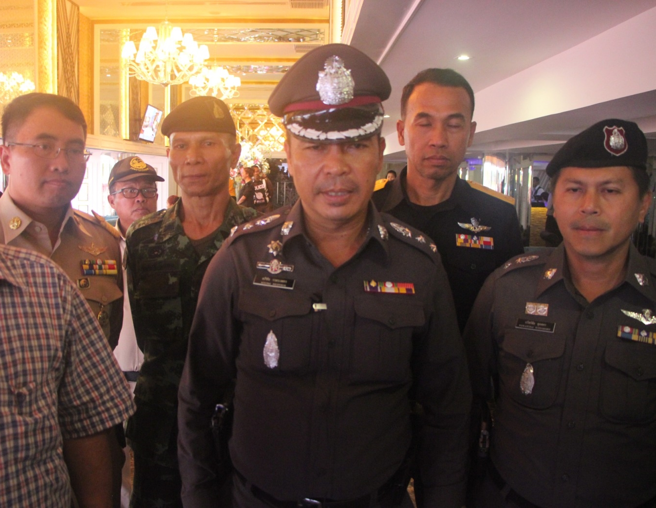 Apichai Klobpetch (middle) speaks to reporters Wednesday night during the inspection of a massage parlor in Pattaya.