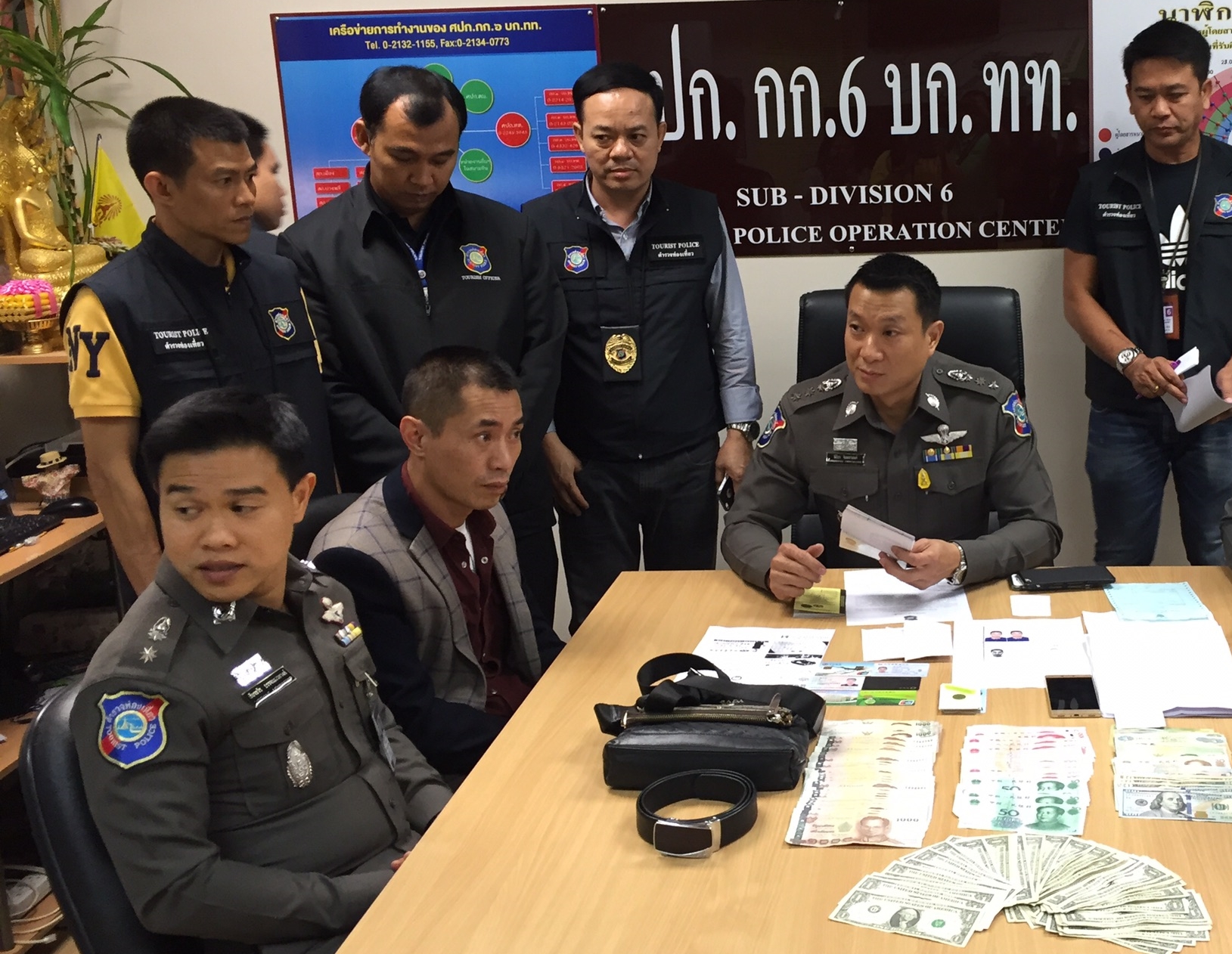 Sheng Wanjun, seated second from the left, at Monday’s police news conference at a Tourist Police station in Bangkok.