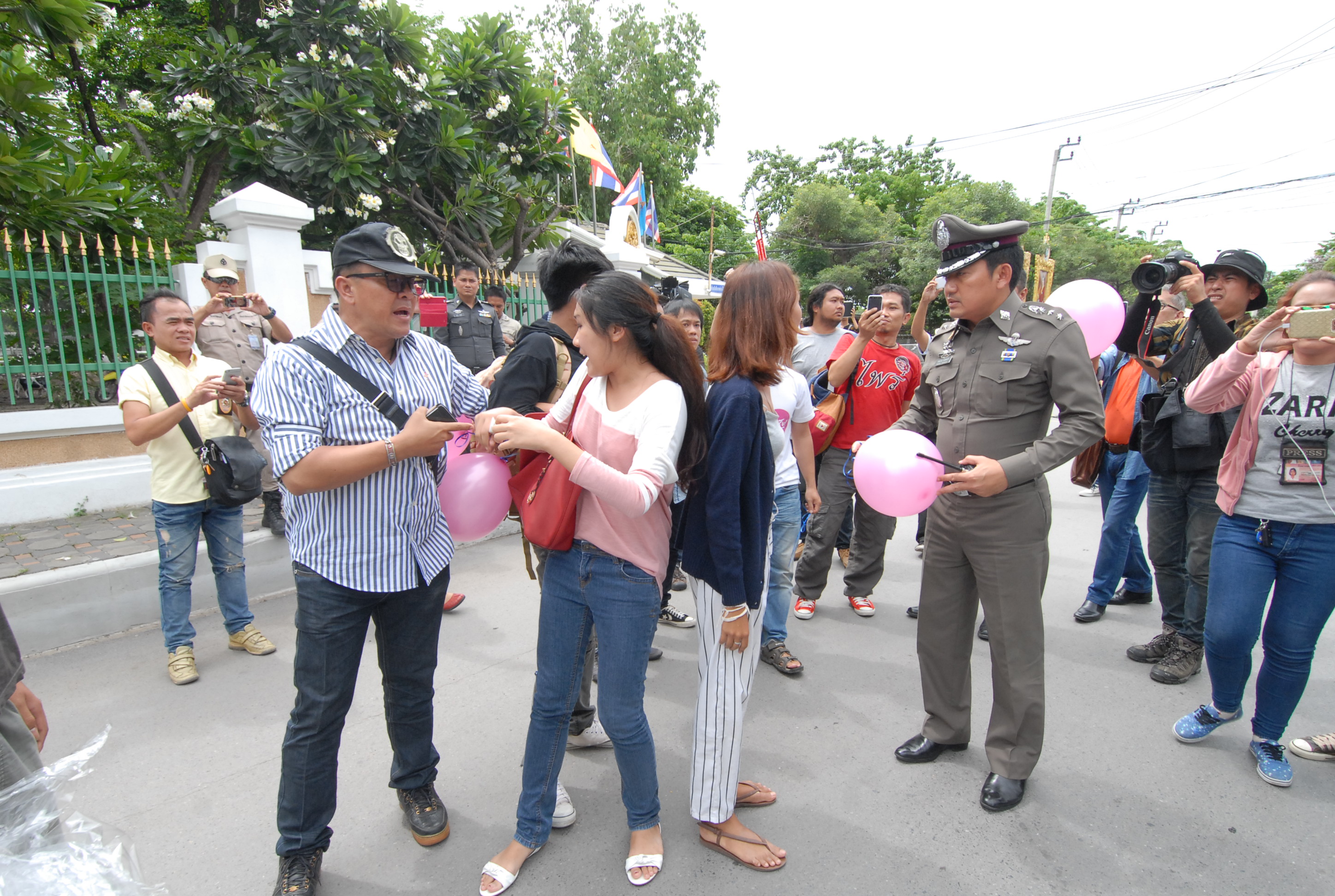 Security officers seize pink balloons as they break up a small rally in support of seven jailed referendum campaigners on Monday in front of the Bangkok Remand Prison.