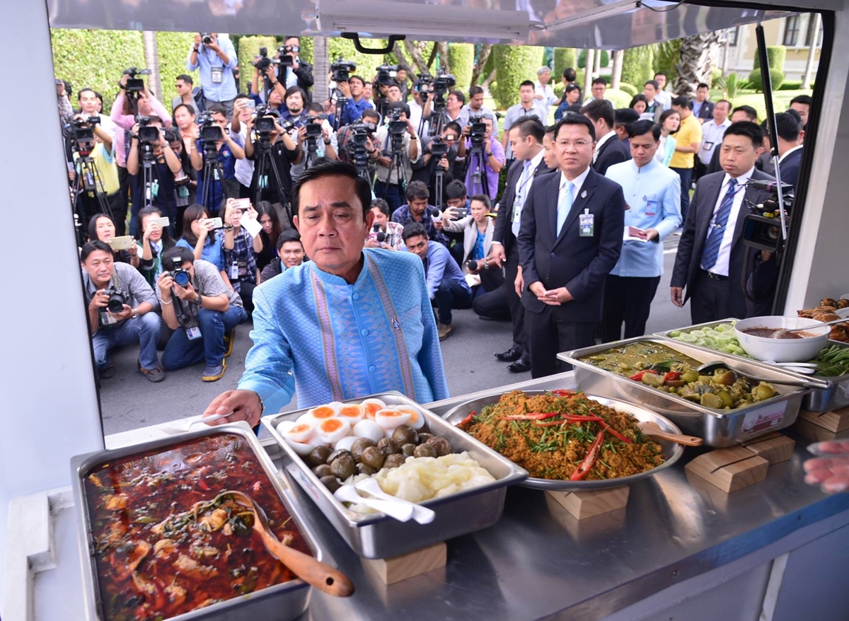 Junta chairman Prayuth Chan-ocha on Tuesday chooses food from a truck at Government House in Bangkok. He’s set to pick 30 new members of the interim parliament next month.
