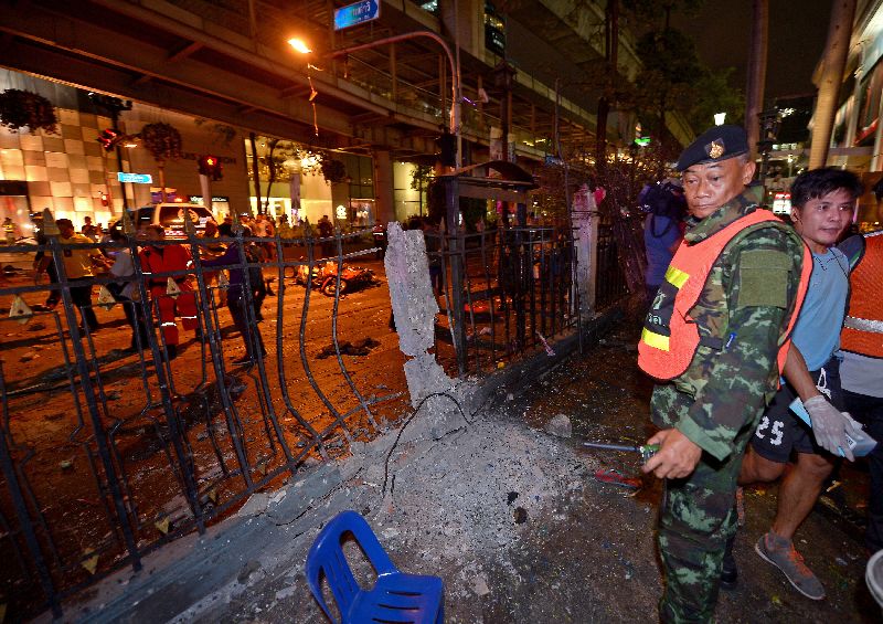 Military and police officers on Aug. 17, 2015, inspect the scene of carnage at Erawan Shrine in Bangkok.