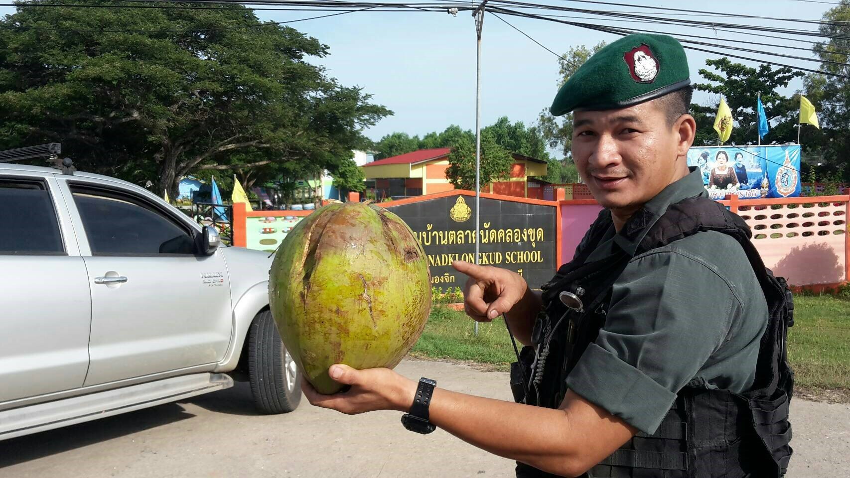 An officer points at the false-alarm coconut Tuesday in Pattani province.