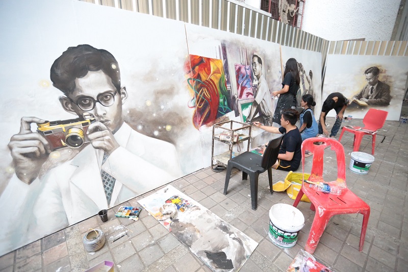 Art students on Monday painting His Majesty the Late King’s portraits on the walls of Silpakorn University (Wang Tha Phra campus)