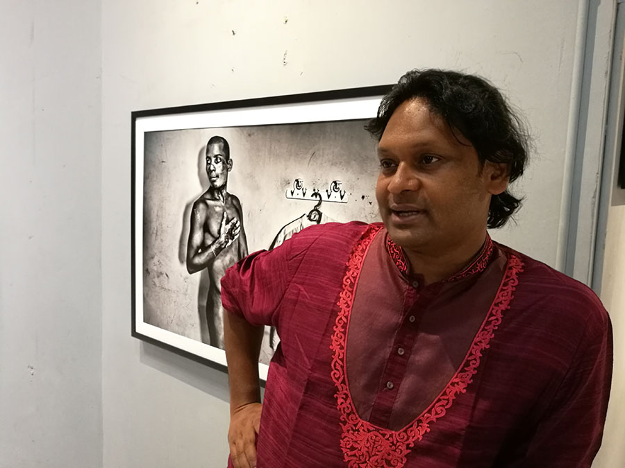 Photographer Saiful Huq Omi stands before one of his photos at Hof Art Space in Bangkok.