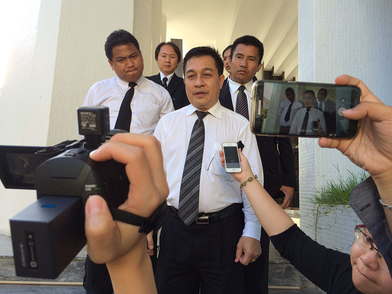Defense attorney Schoochart Kanpai speaks to reporters outside the court Tuesday in Bangkok on the opening day of a trial against two men accused of bombing the Erawan Shrine in August 2015.