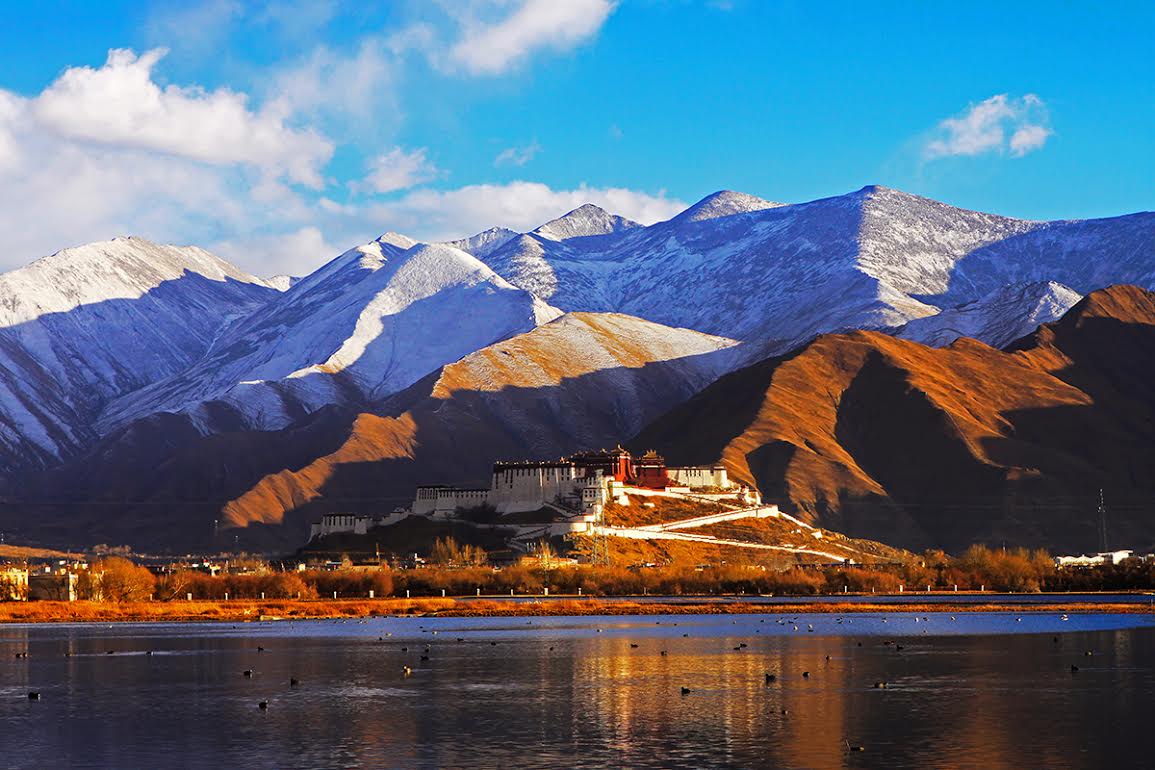 The Tibetan Potala Palace sits beneath the enormity of Mt. Everest. Photo: Xinhua News Agency / Courtesy