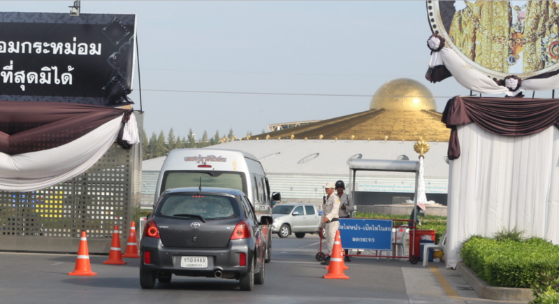 Guards search vehicles entering Wat Dhammakaya on Wednesday in Pathum Thani province.