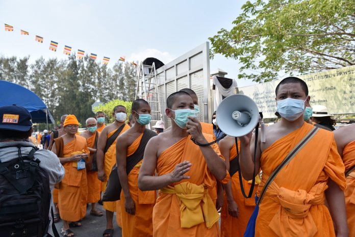 Dhammakaya monks address their supporters via loudspeakers just outside Wat Dhammakaya on Sunday.