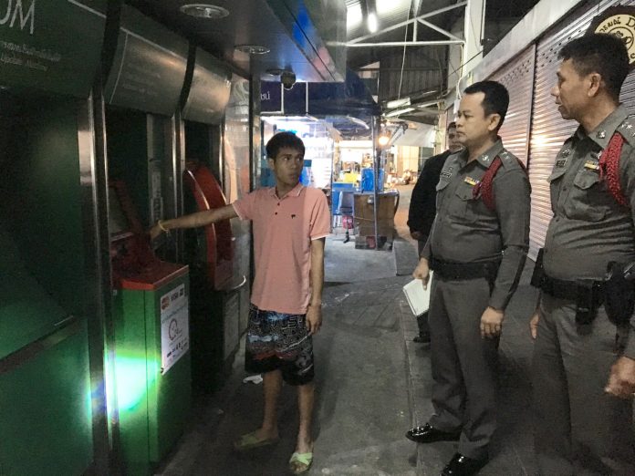 Srawut Pungprasop, shows police the ATM he claimed to be using when he was allegedly robbed Tuesday night in Bang Khen.