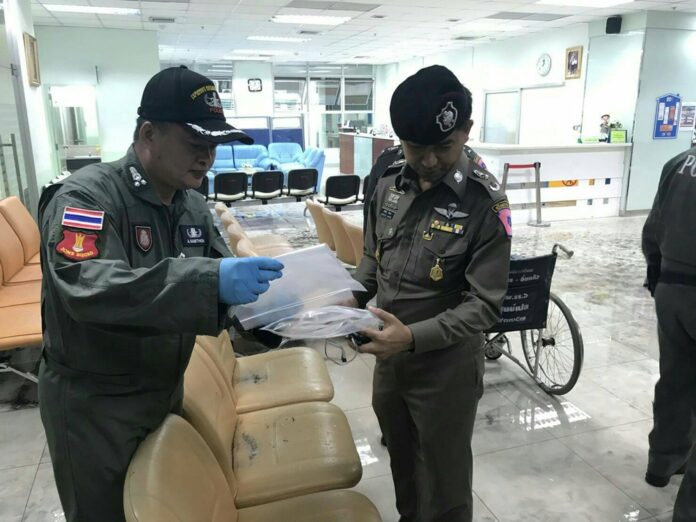 Police and military officers collect evidence Monday at the scene of bombing at Phramongkutklao Hospital.