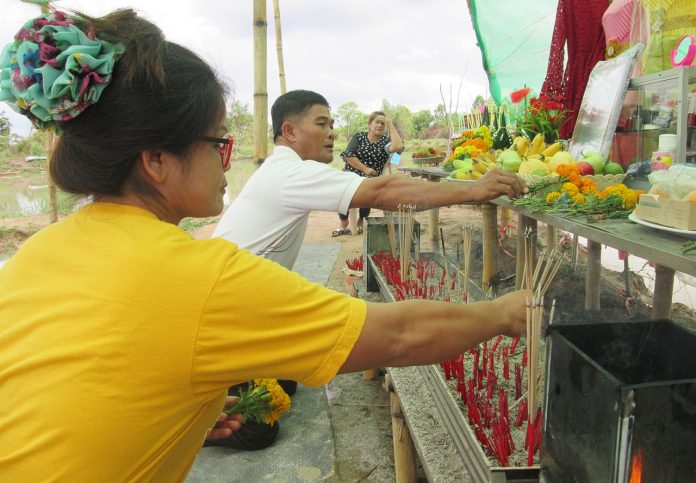 Residents offer incense sticks to a mango tree Thursday in Nakhon Phanom.