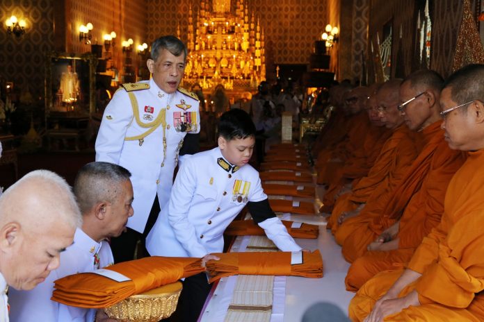 King Vajiralongkorn and his son Dipangkorn Rasmijoti make merit for the late King Bhumibol at the Temple of the Emerald Buddha on Dec. 2, 2016.