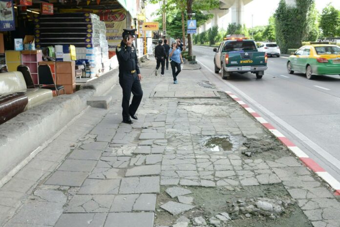 In this undated photo, a tessakit inspects broken sidewalks in Bangkok. Photo: Matichon