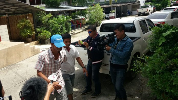Nawik Jareuk, in blue cap, is led into the Khokkloi Police Station on Monday in Phang Nga province.