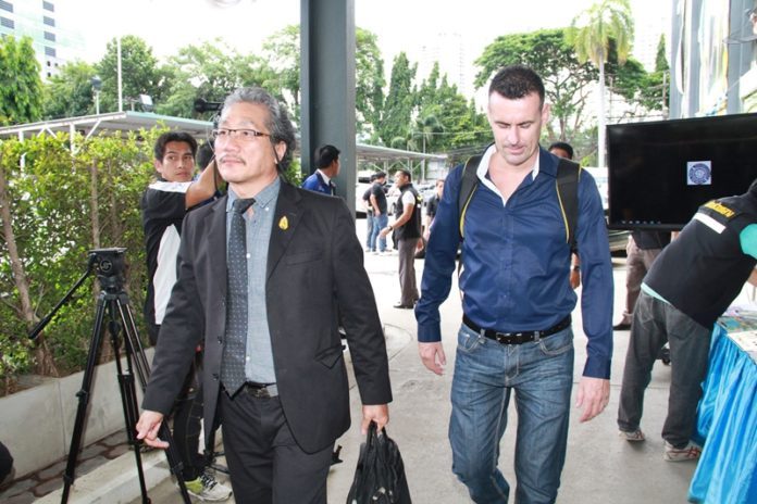 Cedric Servan, at right, arrives his lawyer, Tatpol Chuenchopruk, on July 7 to the Crime Suppression Division in Bangkok.
