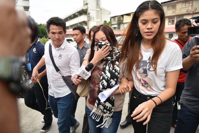 Jariyaporn ‘Nammon’ Buayai on Friday is led to a police news conference.