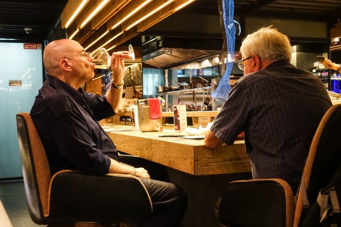 Customers drink wine in June at a Bangkok restaurant.