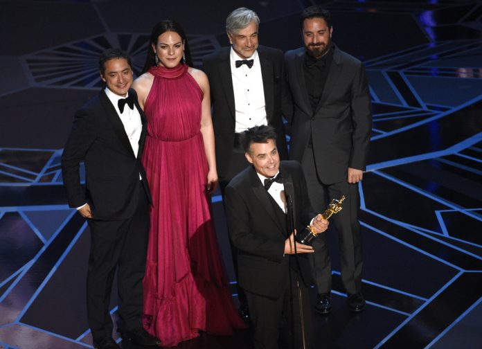 Sebastian Lelio, foreground center, and Nicolas Saavedra, from back left, Daniela Vega, Alejandro Goic, and Pablo Larrain accept the award for best foreign language film for