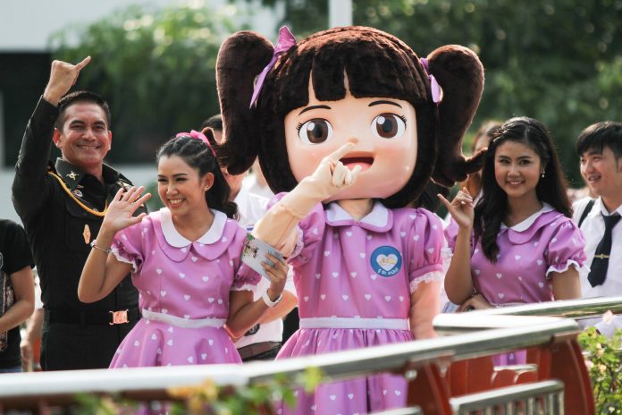 Military spokesman Wanchana Sawasdee, at left, and a mascot promoting national reconciliation campaign April 6 at Victory Monument in Bangkok.