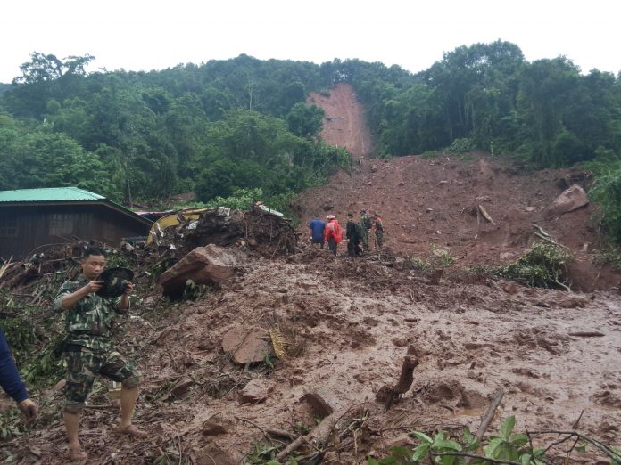 An image shows a small northern community buried under mud Saturday in Nan province.