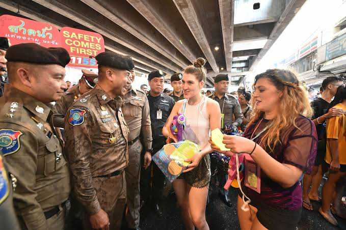 In this undated photo, Lt. Gen. Surachate Hakparn, left, talks to foreigners in Bangkok during the Songkran festivities.