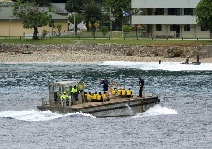 A group of Vietnamese asylum seekers are taken by barge to a jetty in 2013 on Australia's Christmas Island. Photo: Associated Press A group of Vietnamese asylum seekers are taken by barge to a jetty in 2013 on Australia's Christmas Island. Photo: Associated Press