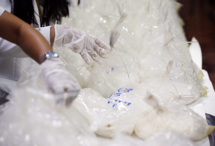 In this May 29, 2017, file photo, members of the National Bureau of Investigation arrange packs of seized methamphetamine at the National Bureau of Investigation in Manila, Philippines. Photo: Aaron Favila / Associated Press