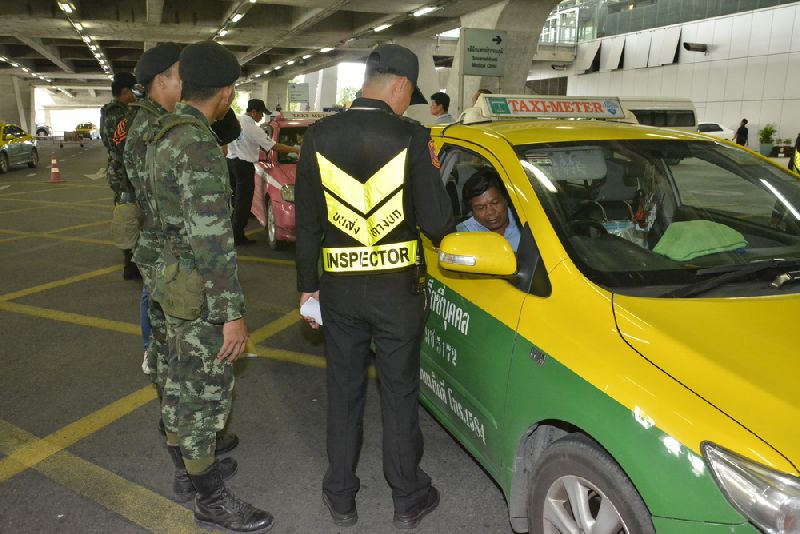 Security officers inspect taxis at Suvarnabhumi Airport in Bangkok on 19 June 2014