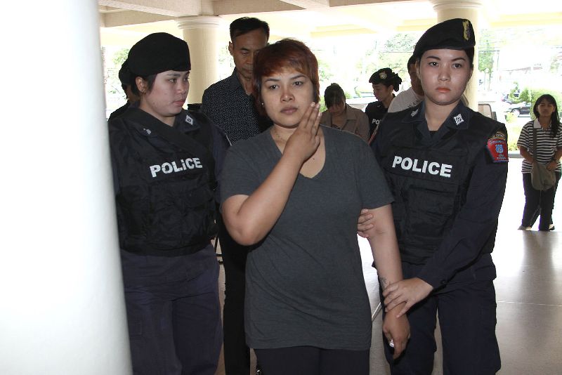 Nattathida Meewangpla flashing an anti-coup hand gesture while police escort her to their HQ in Bangkok on 17 March 2015.