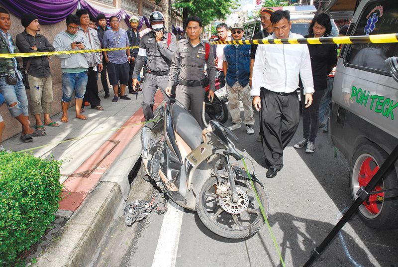 Police inspect the scene where a 17-year-old student from Siam Technology College was shot dead in a suspected gang assassination in Bangkok on 17 June.<br />