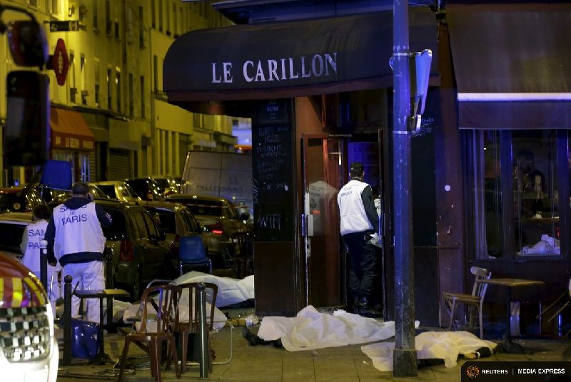 Rescue services near covered bodies outside a restaurant following a Friday shooting in Paris. Photo: Reuters / Philippe Wojazer