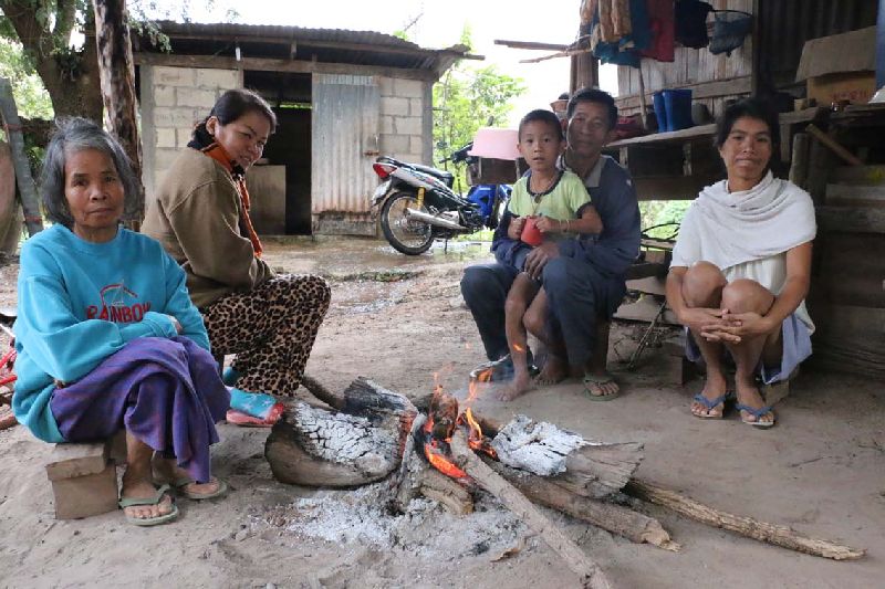 A family huddles around a campfire for warmth this morning in Loei province, where temperatures fell to 9C.