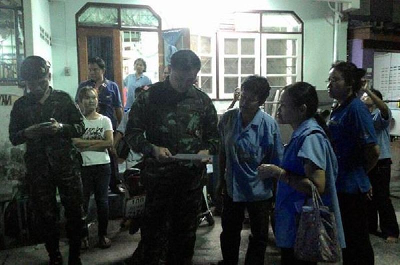 Soldiers pay a visit Jan. 19 to the Samut Sakhon home of labor rights advocate Wilaiwan Sae-tia, second from right in foreground.<br />