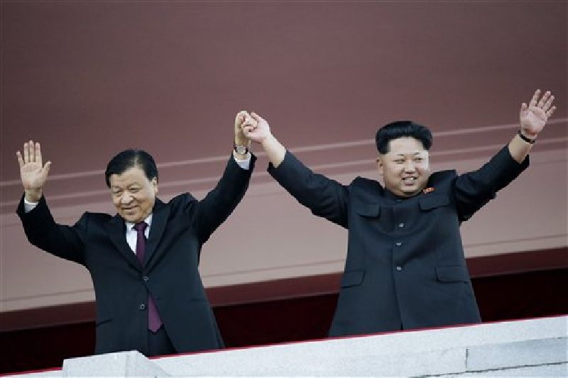 In this Oct. 10, 2015, file photo, North Korean leader Kim Jong Un, right, joins hands and waves with visiting Chinese official Liu Yunshan, the Communist Party's fifth-ranking leader, during a parade in Pyongyang, North Korea. Photo: Wong Maye-E / AP