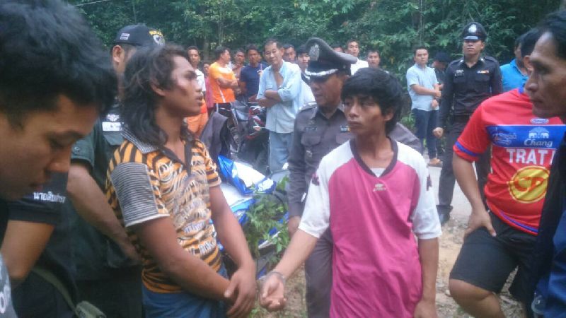 Two suspects, center foreground, in the rape of two French tourists participate Sunday in a ‘re-enactment’ as a crowd gathers on Koh Kut.