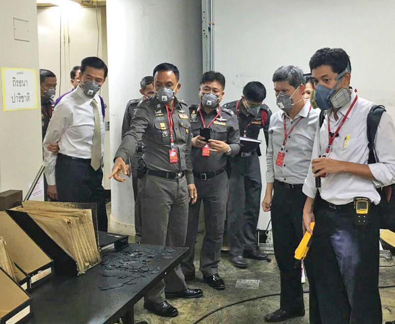 Lt. Gen. Sanit Mahatavorn, foreground second from left, points as investigators Monday inspect the basement of the SCB Park Plaza in Bangkok.