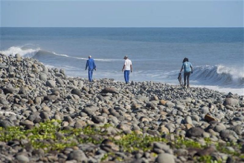 In this Aug. 10, 2015 photo, municipal workers search Reunion Island beaches where expected debris of the missing Malaysia Airlines Flight 370 could be washed up onto the shore near Saint-Andre, Reunion island. Photo: Fabrice Wislez / Associated Press