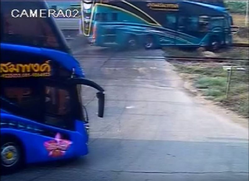 A bus is knocked off the tracks by a train Sunday at an uncontrolled intersection west of Bangkok in a still image from security camera footage.