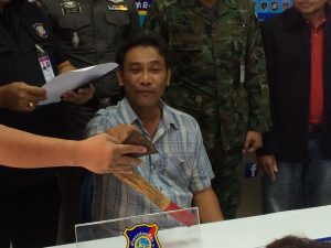At Sunday’s police news conference, Nattawuth Chidjui points to the axe he allegedly used to threaten another motorist.