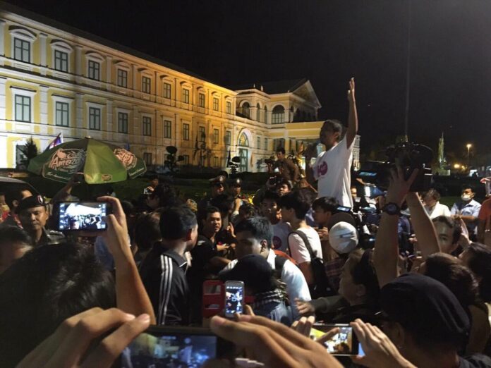 Pro-democracy activists gather in front of military court Friday night in Bangkok to show support for the 13 referendum campaigners arrested yesterday.