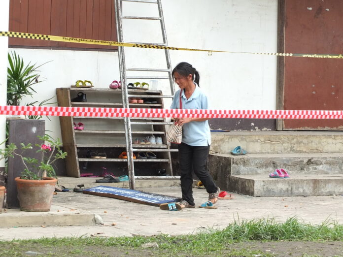 A distraught mother searches the burned-out dorm of Pitakkiat Witthaya school on May 24 for belongings of her daughter who died in the fire.