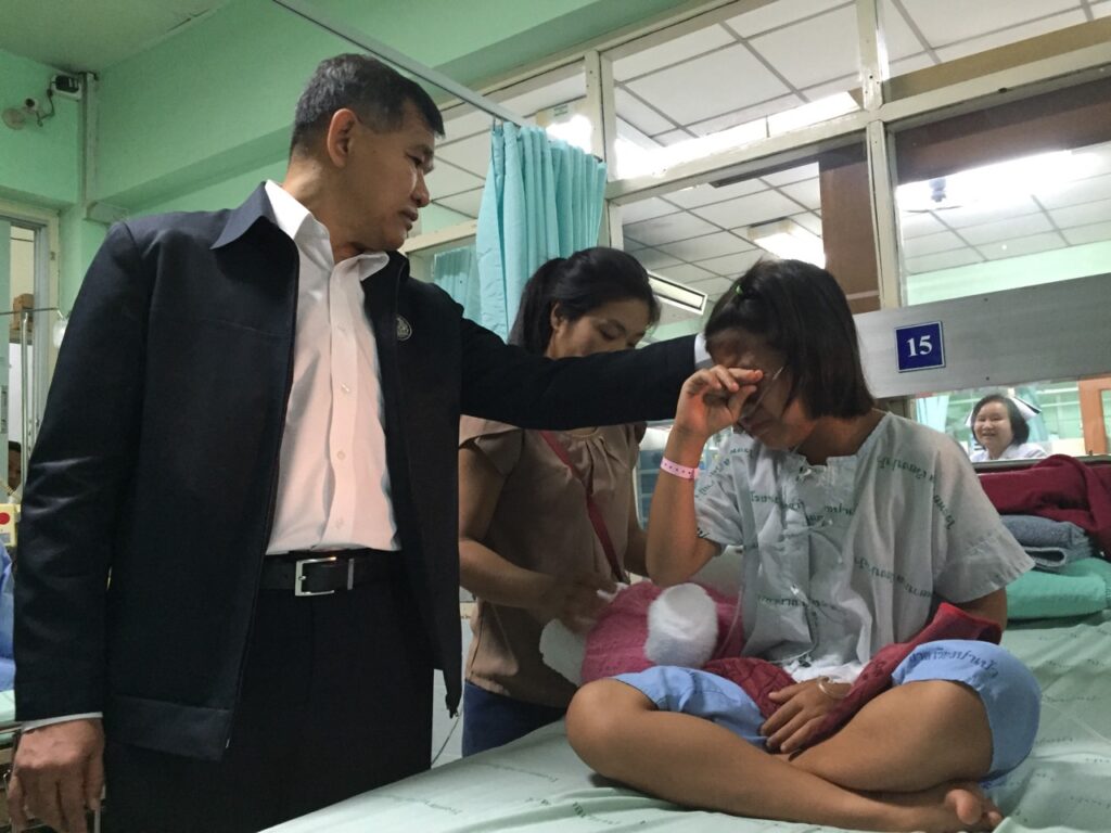 Deputy Minister of Education Surachet Chaiwong consoles a survivor of the fire on May 25 at a hospital in Chiang Rai province