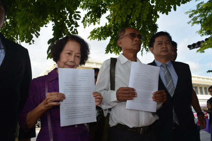 Arporn Worathaiwit, Krit Mahaton and lawyer Winyat Chartmontree show the petition they will submit Friday in front of the Office of His Majesty's Principal Private Secretary in Bangkok.