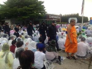 A monk leads police and DSI officers on Thursday morning into the complex of Dhammakaya Temple to search for temple leader Dhammachayo. 