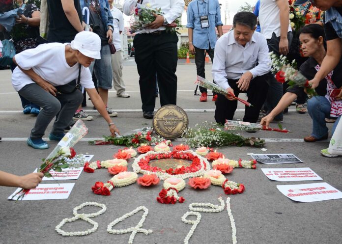 Activists lay down garlands and candles at the 1932 Revolution Plaque this morning in Bangkok.