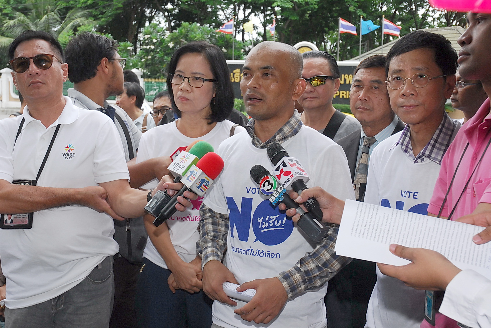 Activists opposed to the junta’s charter draft speak to reporters June 28 in front of Bangkok Remand Prison, where seven campaigners are being jailed for urging the public to vote against the draft.
