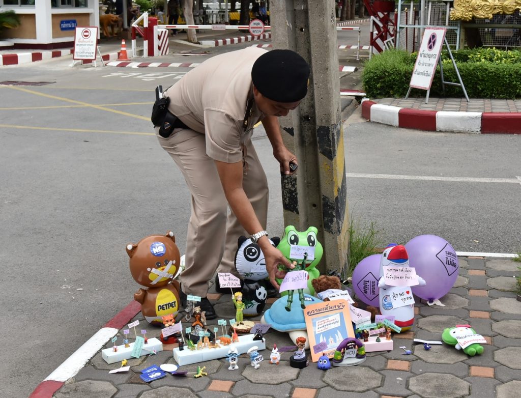 Prison guard confiscating a toy’s placard.