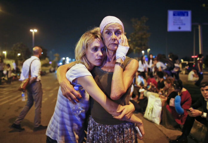 Passengers embrace each other as they wait outside Istanbul's Ataturk airport early Wednesday following their evacuation after a blast. Photo: Emrah Gurel / Associated Press