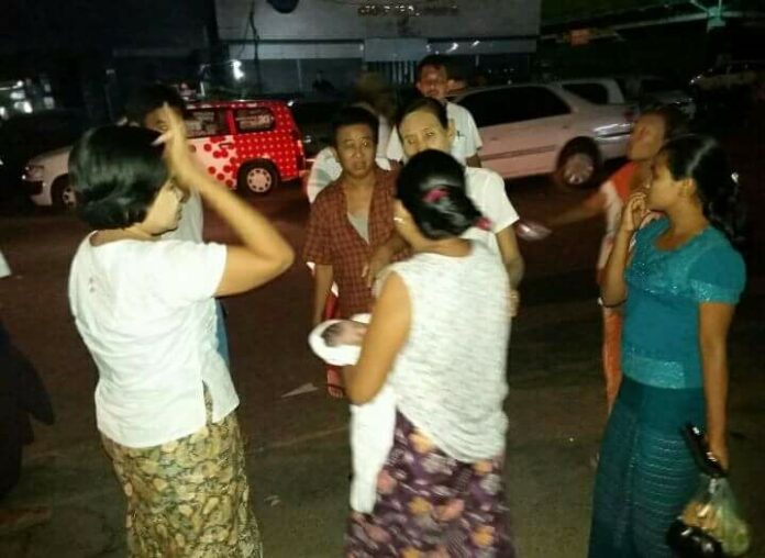 Shocked bystanders gather around an abandoned newborn found in Mingalar Taung Nyunt township, and a lactating mother immediately breast-feeds the baby, on May 12in Yangon. Photo: Thidar Han / Myanmar Now