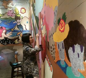 Artist Yuree Kensaku paints her mural. Photo: 100 Tonson Gallery / Facebook